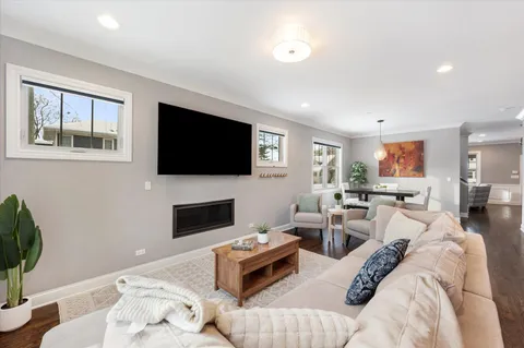 a living room with furniture kitchen and a flat screen tv