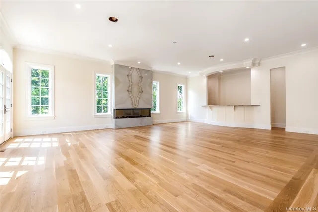 a view of empty room with wooden floor and windows
