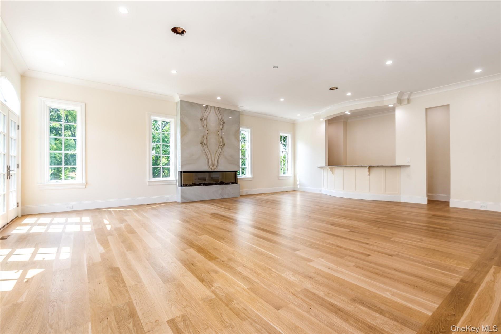 566 East Shore Road Great Neck, NY 11024 - Photo 13 of 50 a view of empty room with wooden floor and windows