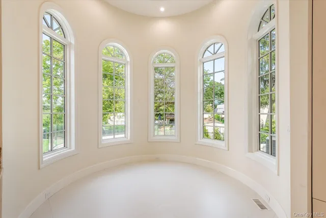 an empty room with windows and view of balcony
