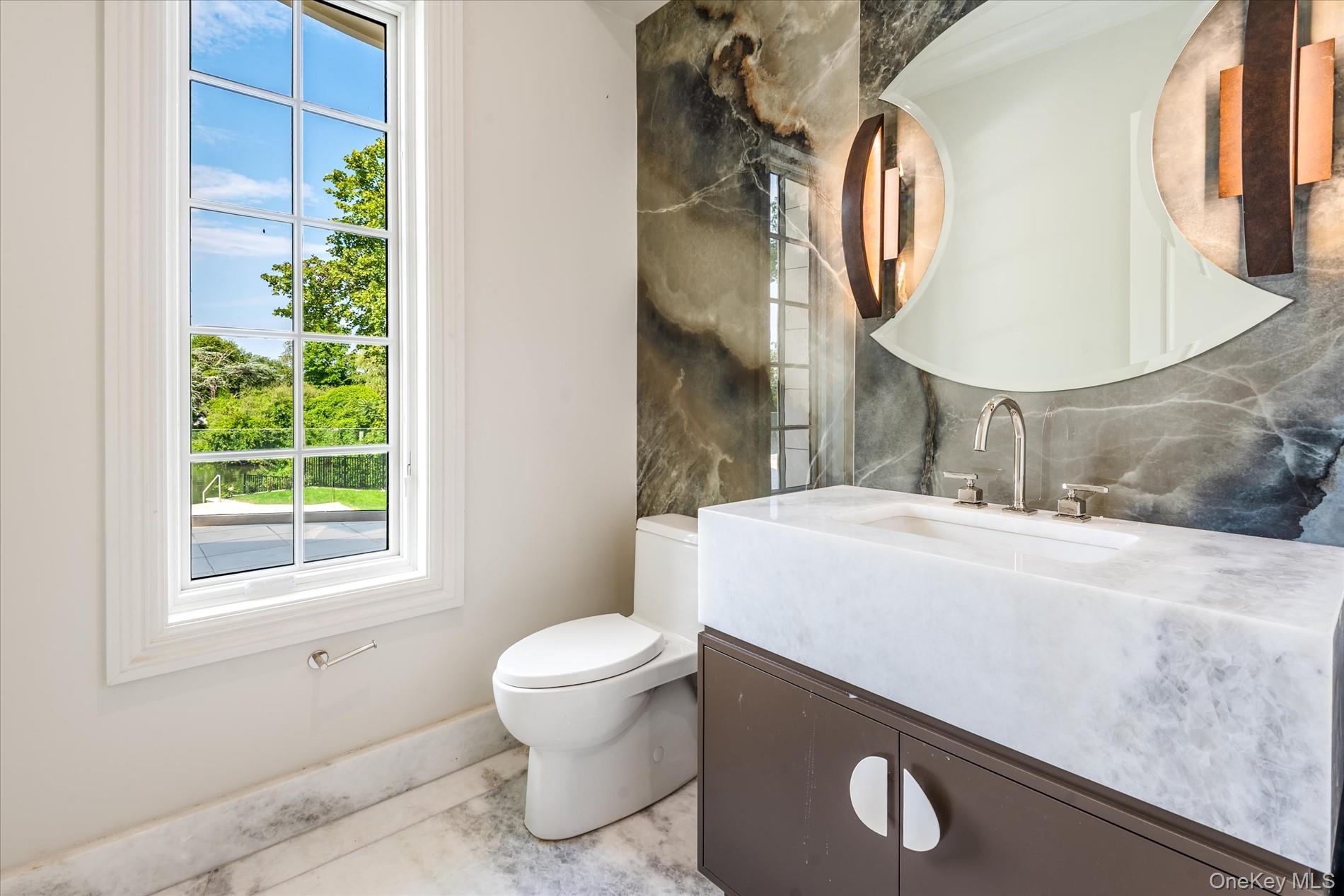 566 East Shore Road Great Neck, NY 11024 - Photo 23 of 50 a bathroom with a sink and a mirror