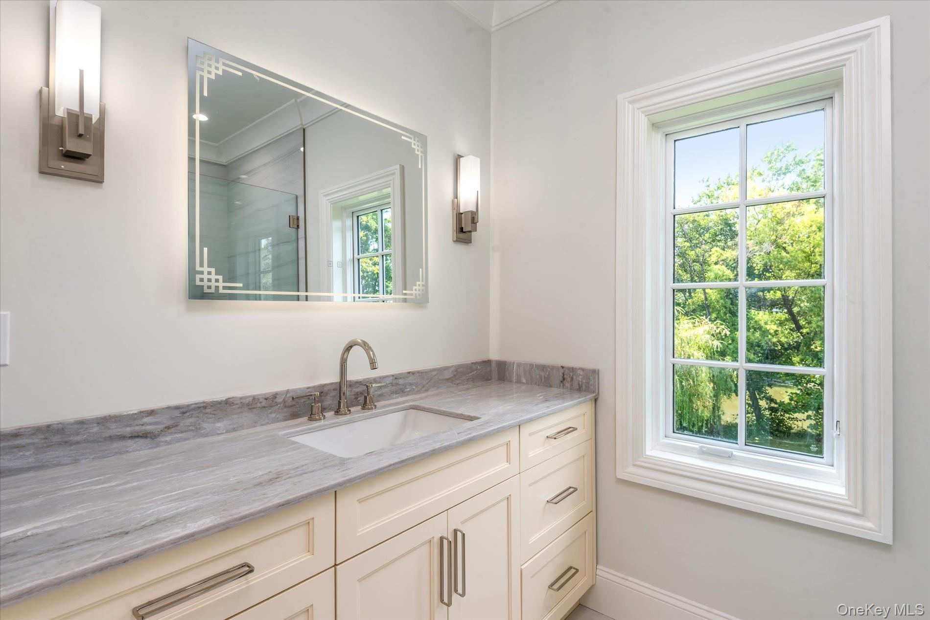 566 East Shore Road Great Neck, NY 11024 - Photo 32 of 50 a bathroom with a granite countertop sink a large mirror and a window
