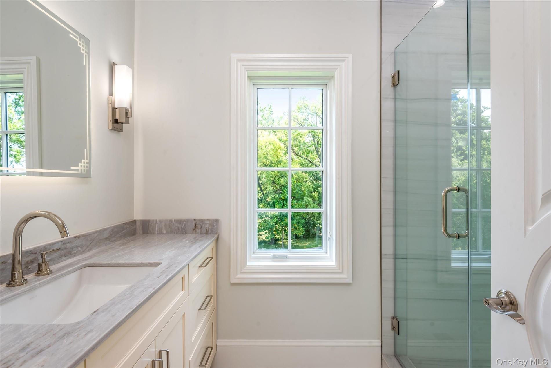 566 East Shore Road Great Neck, NY 11024 - Photo 33 of 50 a bathroom with a granite countertop sink a shower and a mirror