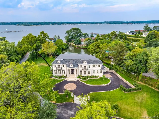 an aerial view of a house with swimming pool and lake view