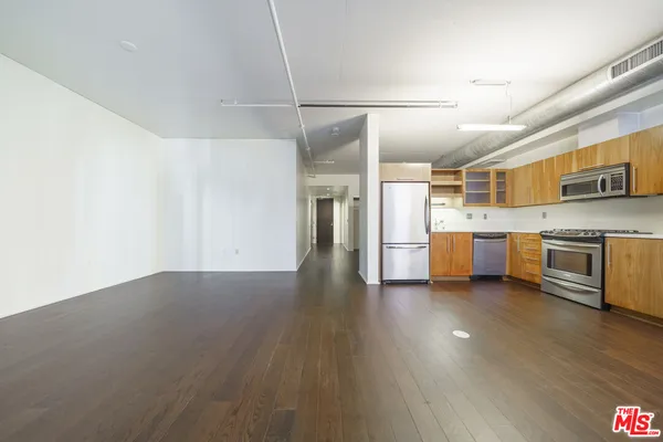 a view of a kitchen with a sink stove cabinets and empty room