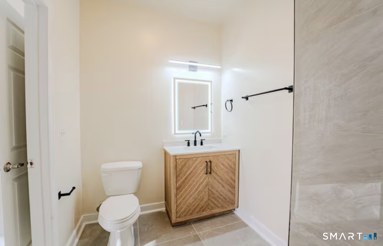 333 State Street, Unit 104 Bridgeport, CT 06604 - Photo 2 of 4 a bathroom with a toilet sink and mirror