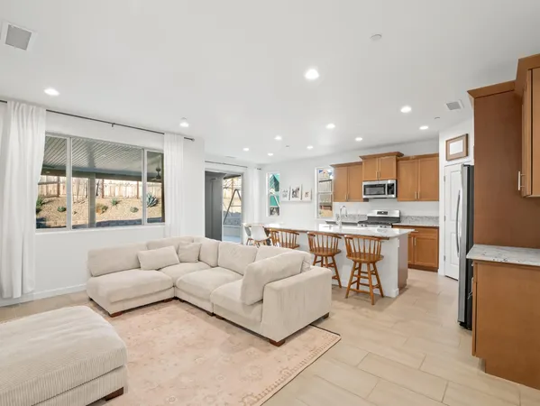 a kitchen with stainless steel appliances granite countertop a stove a sink a microwave a dining table and chairs