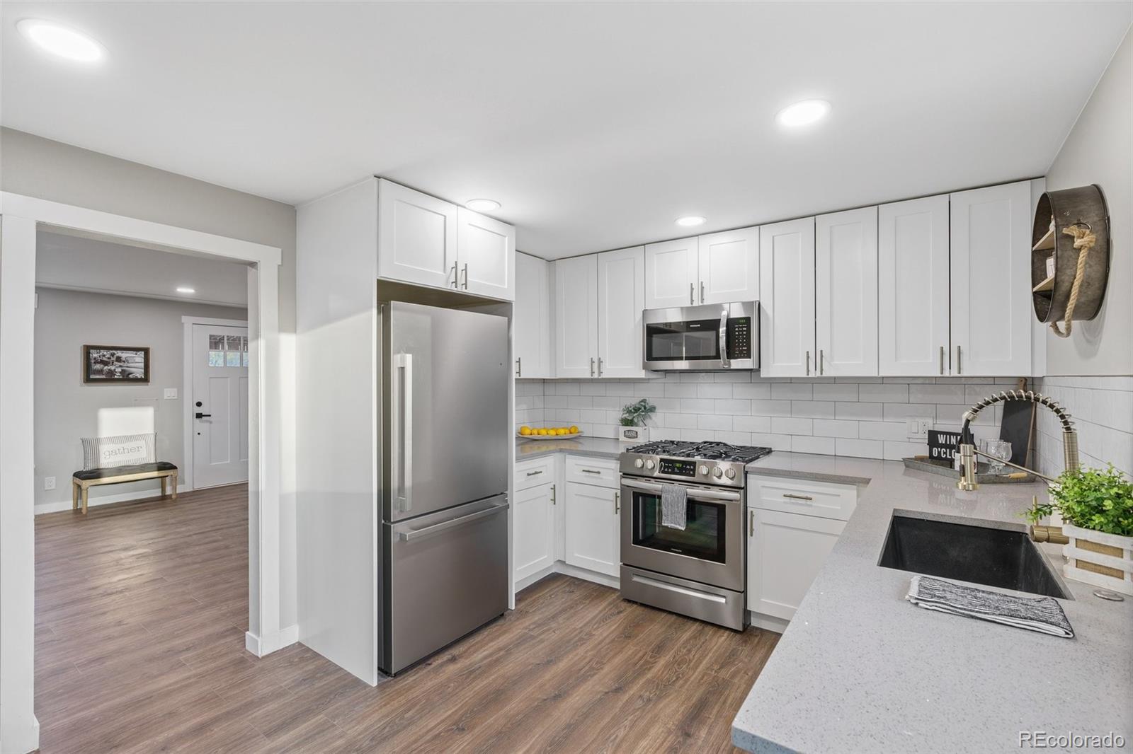 1853 South Decatur Street Denver, CO 80219 - Photo 7 of 22 a kitchen with a refrigerator stove and wooden cabinets