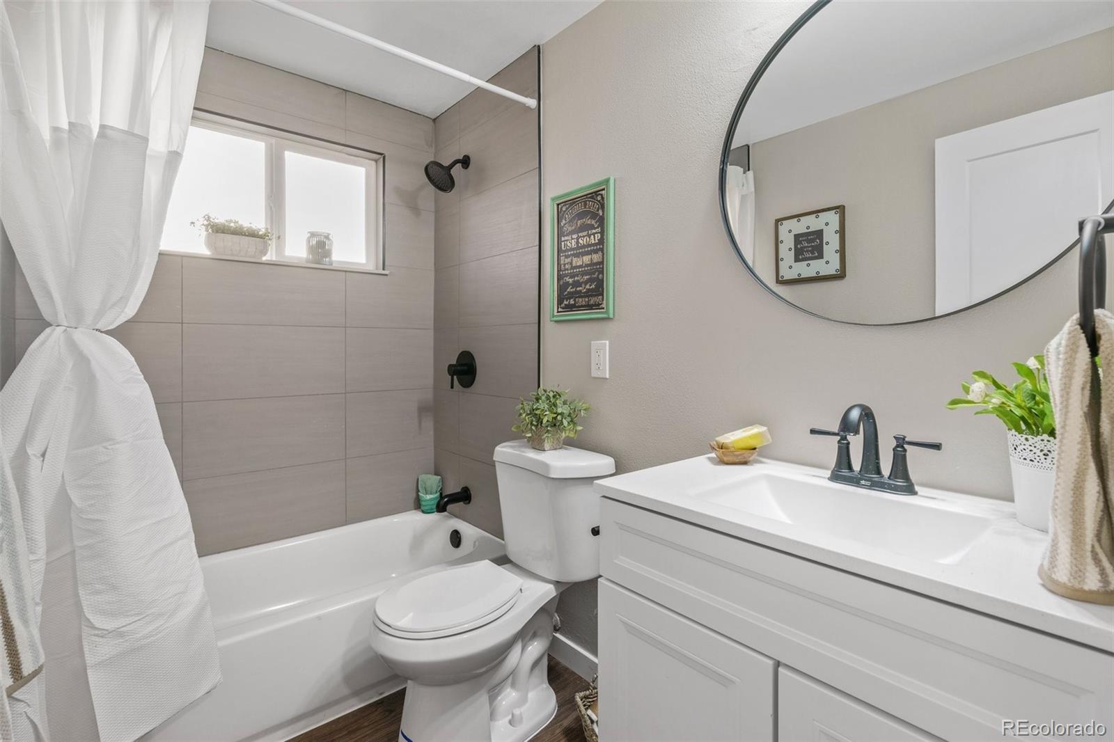 1853 South Decatur Street Denver, CO 80219 - Photo 10 of 22 a bathroom with a sink a toilet a mirror and shower
