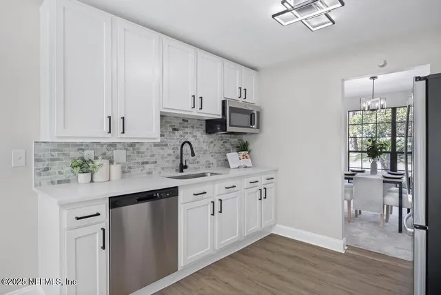 a kitchen with stainless steel appliances granite countertop a sink a stove and cabinets