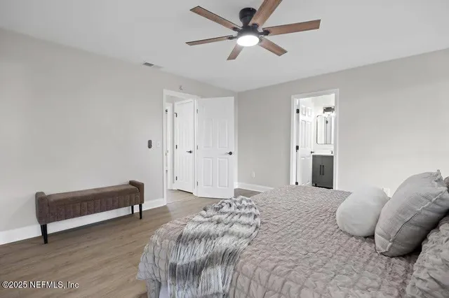 a spacious bedroom with a bed and a chandelier