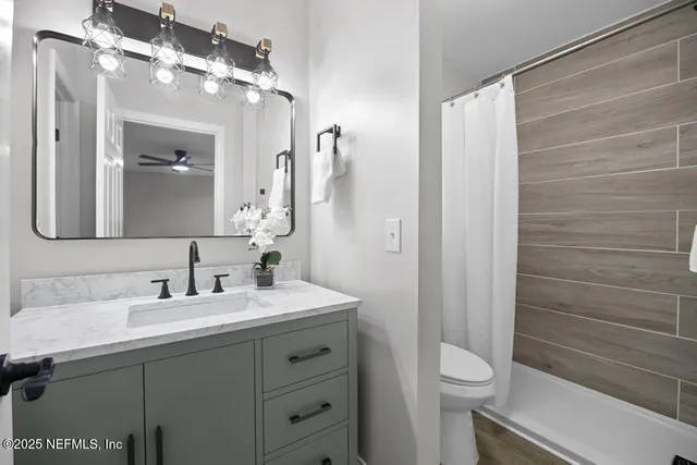 a bathroom with a sink a toilet and shower