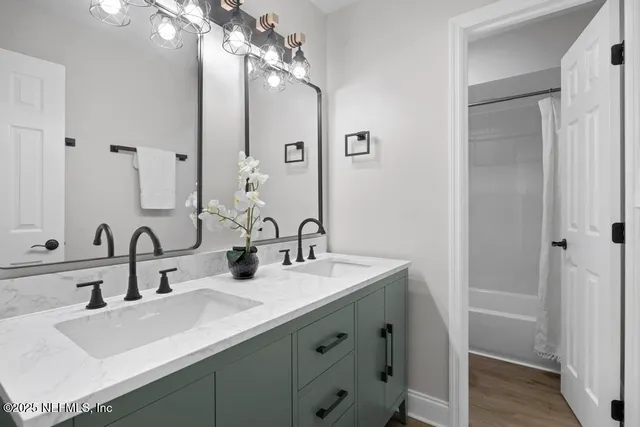 a bathroom with double vanity sinks and a mirror