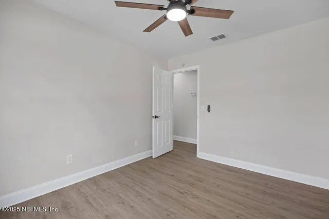 a view of an empty room with wooden floor