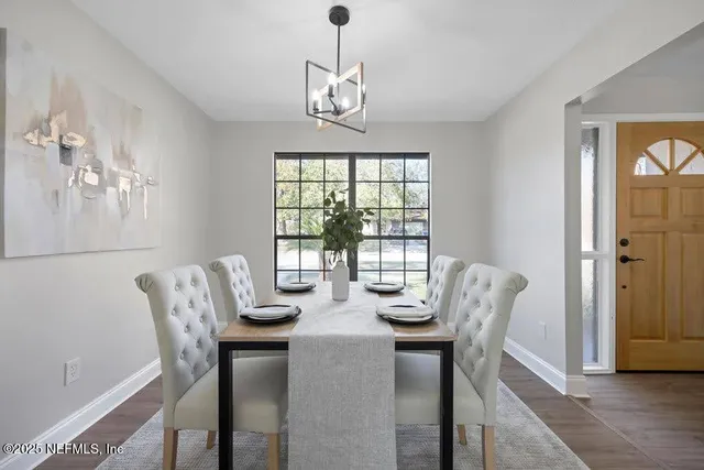 a dining room with furniture a chandelier and wooden floor