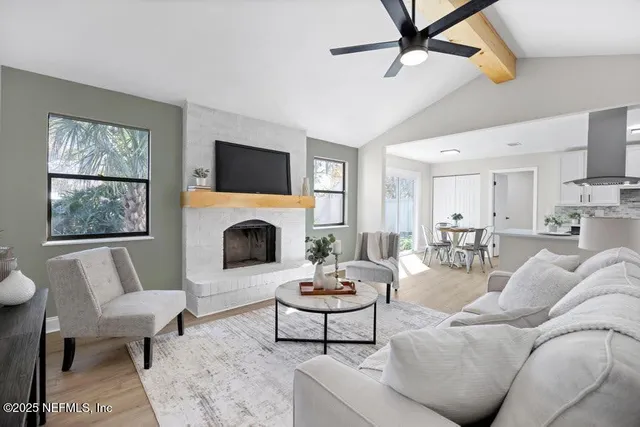 a living room with furniture a fireplace and a flat screen tv