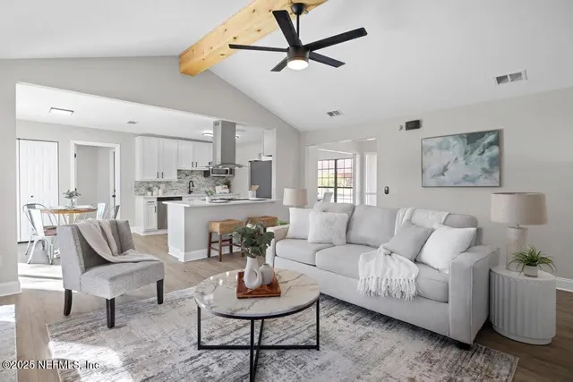 a living room with furniture and kitchen view
