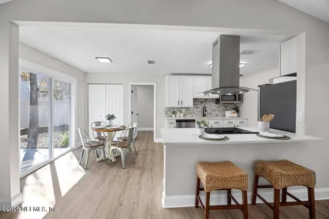a kitchen with a dining table chairs and refrigerator