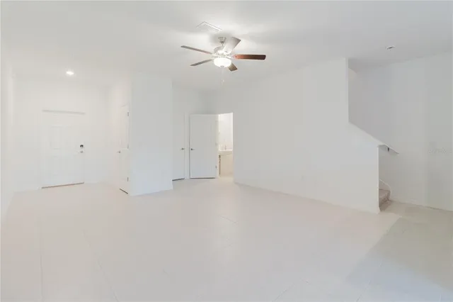 a view of a livingroom with a ceiling fan and a kitchen floor