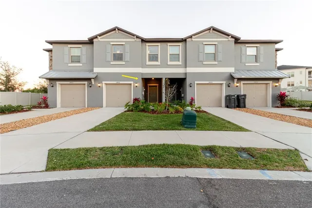 a front view of a house with a garden and garage