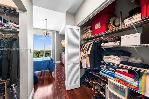 a view of walk in closet with clothes and shoes