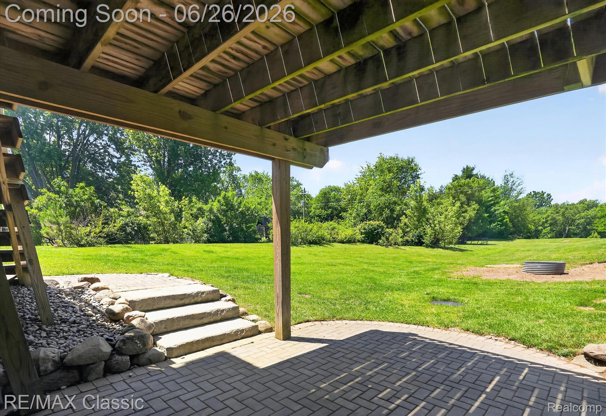 3205 North Milford Road Highland, MI 48357 - Photo 43 of 53 Expansive green space featuring a ground-level paver patio, stone steps, and a wood deck overhead