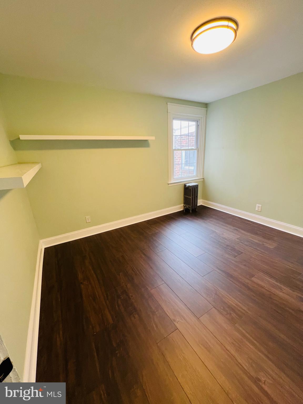 223 Maypole Road Upper Darby, PA 19082 - Photo 14 of 48 a view of an empty room with wooden floor and a window