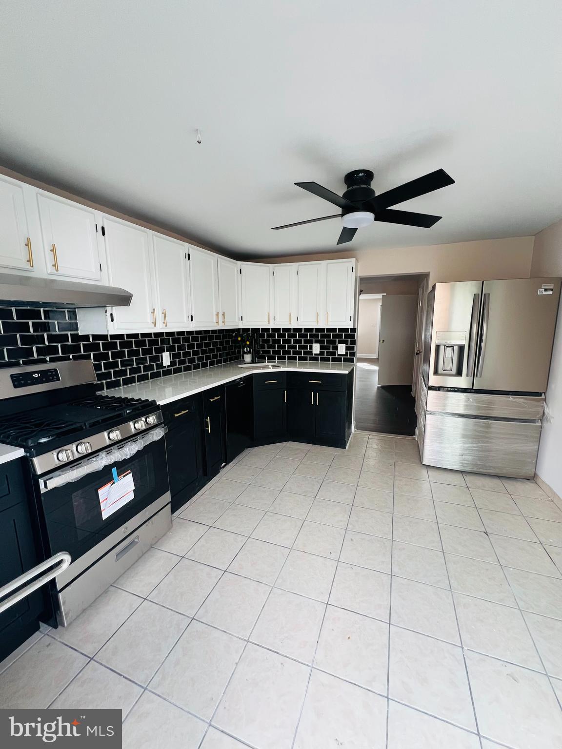 223 Maypole Road Upper Darby, PA 19082 - Photo 23 of 48 a kitchen with granite countertop a refrigerator and a stove top oven