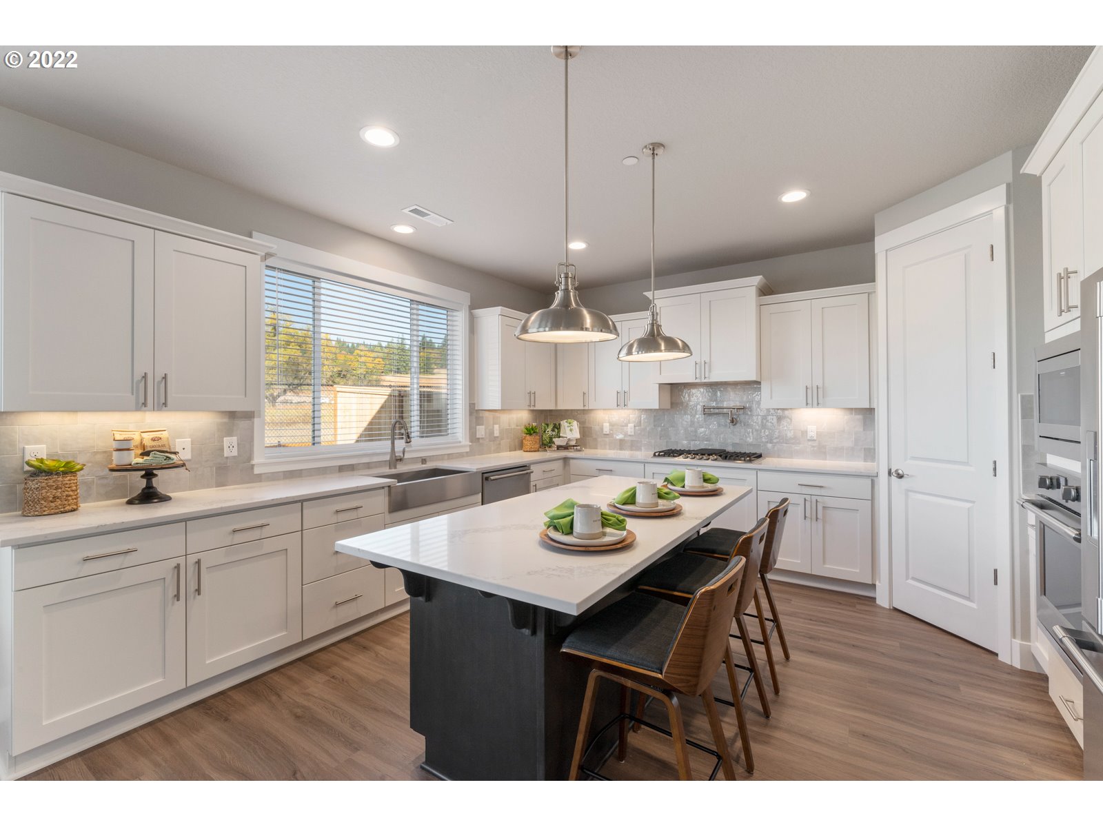 5657 North 92nd Avenue Camas, WA 98607 - Photo 10 of 32 a kitchen with a dining table chairs wooden cabinets and wooden floor