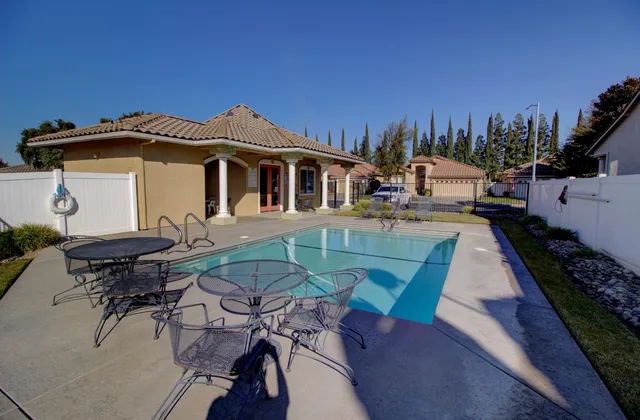 an aerial view of a house with swimming pool and outdoor seating