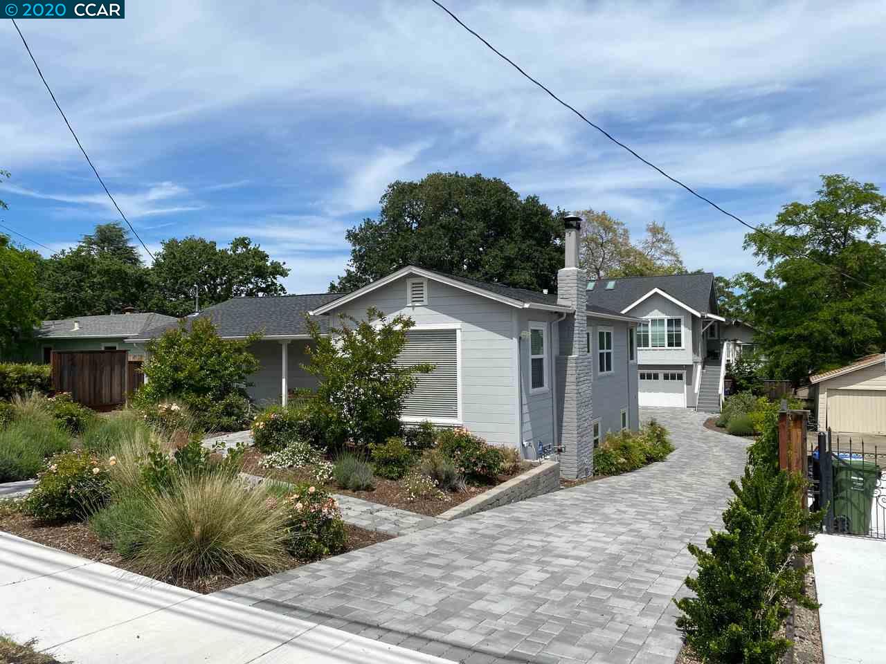 a front view of a house with a yard and potted plants