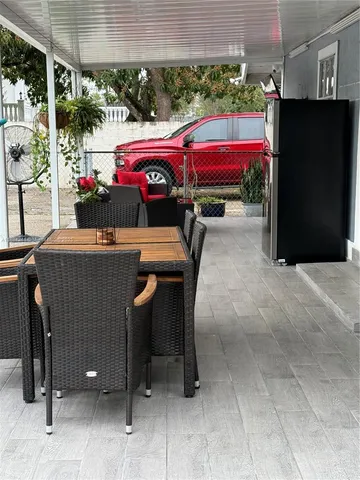 a view of a patio with table and chairs potted plants