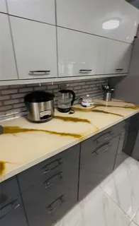 a view of a sink with wooden cabinets