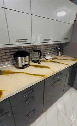 a view of a sink with wooden cabinets