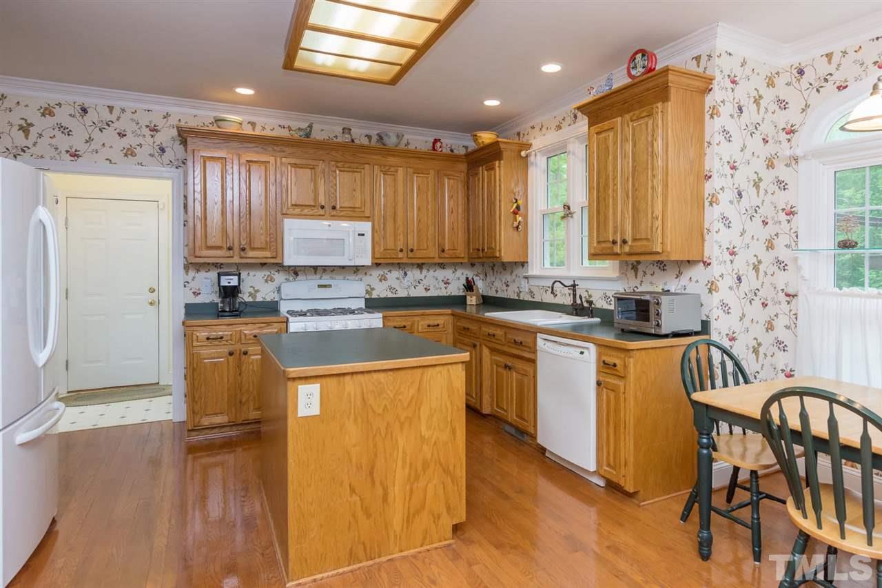 6104 Hampton Ridge Road Raleigh, NC 27603 - Photo 5 of 23 a kitchen with granite countertop a refrigerator a stove top oven a sink and dishwasher
