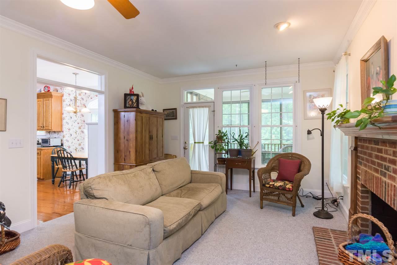 6104 Hampton Ridge Road Raleigh, NC 27603 - Photo 10 of 23 a living room with furniture a fireplace and a chandelier