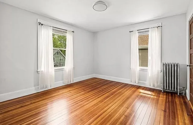 a view of a room with wooden floor and a window