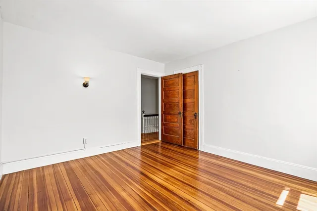 an empty room with wooden floor and closet