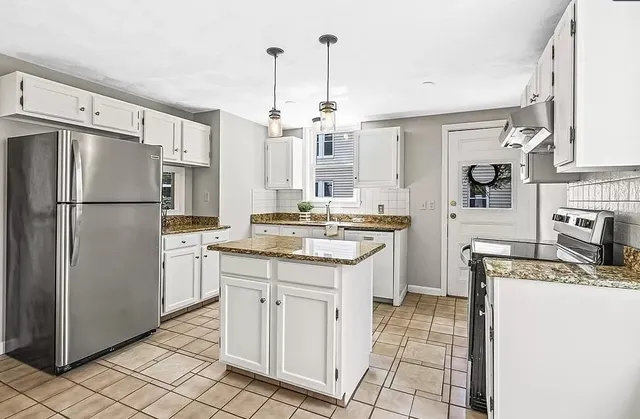 a kitchen with granite countertop appliances a sink and a refrigerator