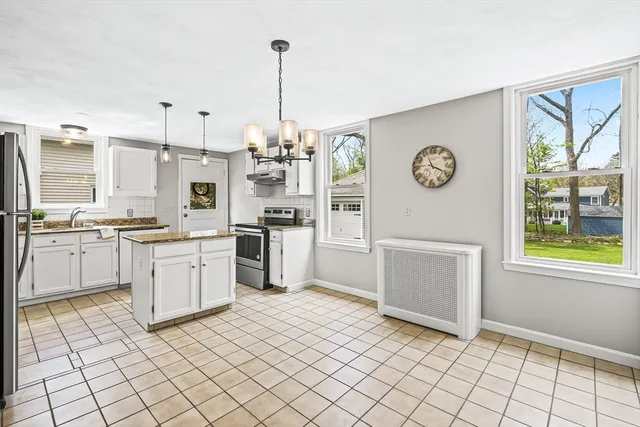 a kitchen with a refrigerator a stove top oven and a clock