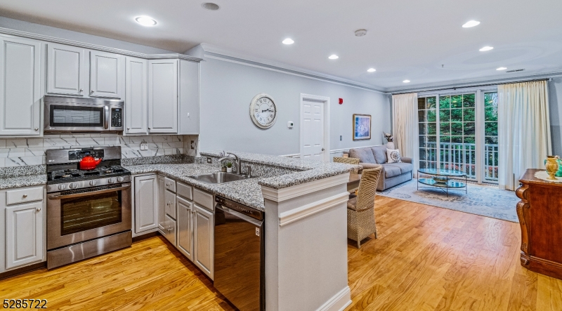a kitchen with kitchen island granite countertop a stove and a sink