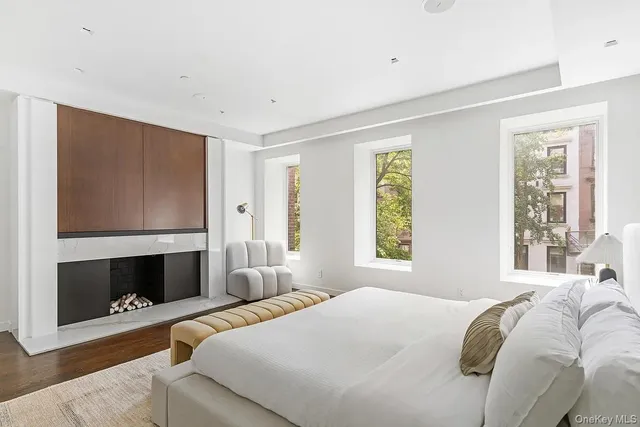 a bedroom with a bed a fireplace and window