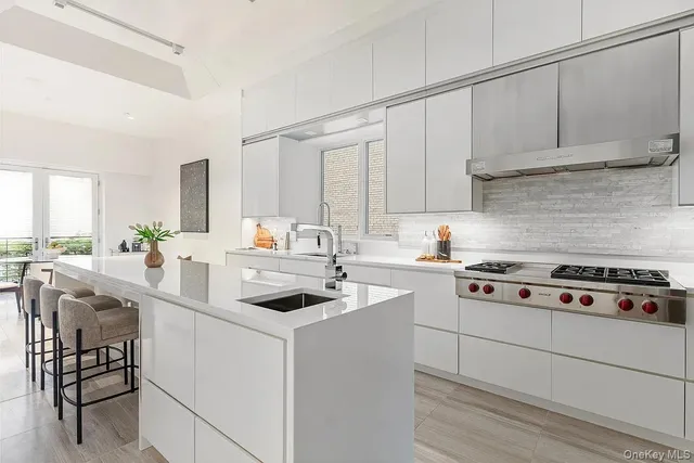 a kitchen with white cabinets and appliances