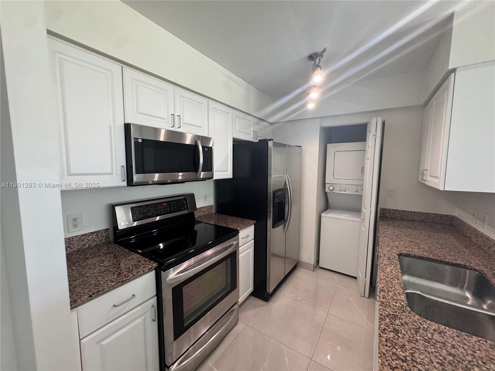 1250 South Miami Avenue, Unit 1404 Miami, FL 33130 - Photo 5 of 8 a kitchen with granite countertop a refrigerator stove and microwave