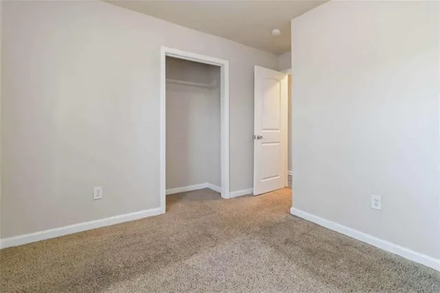 an empty room with closet and a bathroom