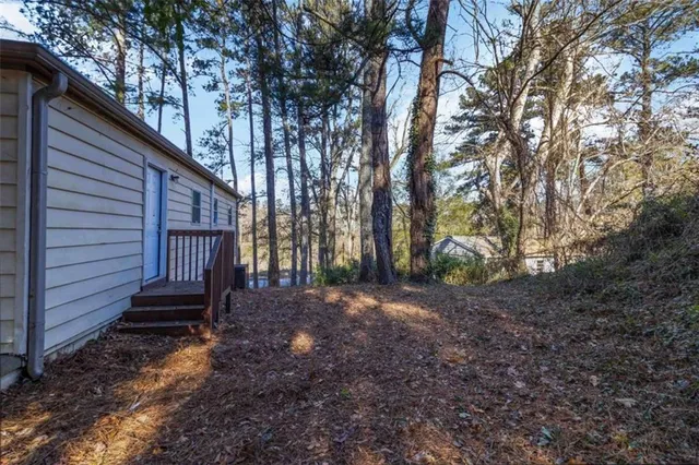 a view of a house with backyard and trees