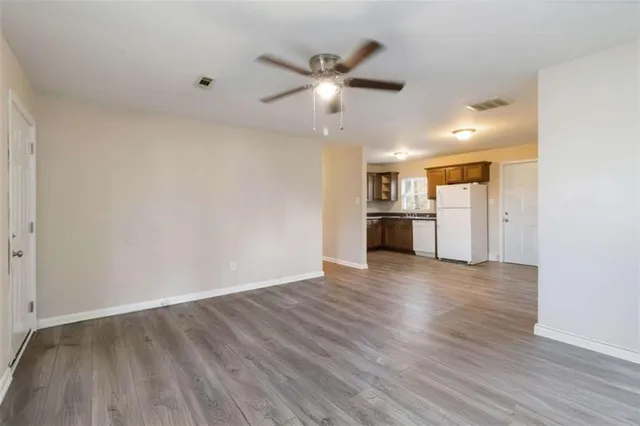 wooden floor in an empty room with a kitchen