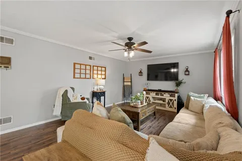 a living room with furniture a flat screen tv and a window