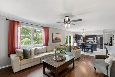 a living room with furniture a table and a large window