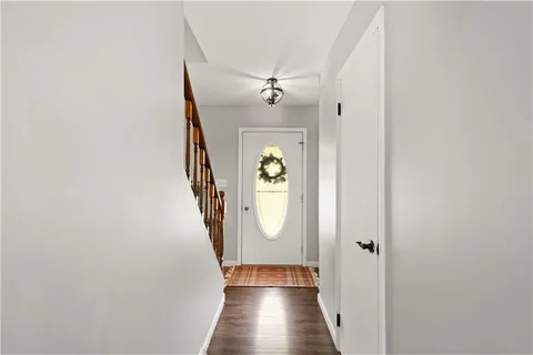a view of a hallway with wooden floor and staircase